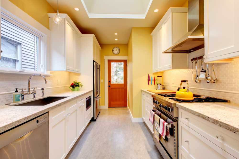looking into a ten by ten small kitchen with brand new white cabinets and quartz countertops